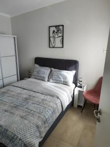 a bedroom with a bed and a red chair at Ismini's Luxury Villas in Mirodháton