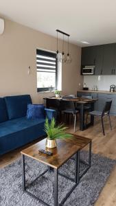 a living room with a blue couch and a table at Domki Pod Łysicą- domki z basenem in Krajno Pierwsze