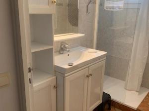a white bathroom with a sink and a shower at Charmant T2 lumineux avec balcon, proche des thermes - FR-1-503-144 in Balaruc-les-Bains +7 photos