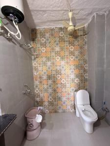 Un baño con inodoro y una pared de azulejos. en Hotel Temple View, en Jaisalmer