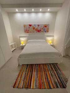 ヴェローナにあるMaison Bassiniのベッドと壁に絵が飾られた寝室