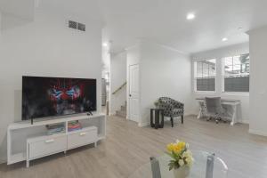 un salon avec une télévision à écran plat et une table dans l'établissement Stylish Pasadena Stay Near Old Town & Rose Bowl, à East Pasadena