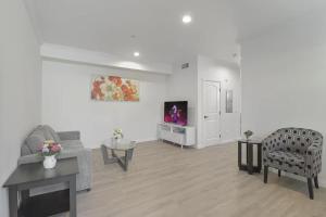 un salon avec un canapé, des chaises et une télévision dans l'établissement Stylish Pasadena Stay Near Old Town & Rose Bowl, à East Pasadena 6 autres photos