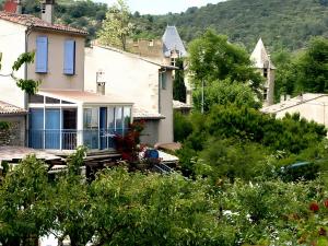 アルマーニュ・アン・プロバンスにあるGîte Marionの青窓と木々のある白い家