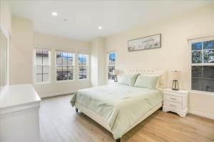 a white bedroom with a large bed and windows at Newly Built Pasadena Retreat Parking Great Location in East Pasadena