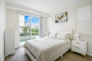 a white bedroom with a large bed and a window at Newly Built Pasadena Retreat Parking Great Location in East Pasadena
