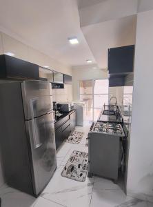 a kitchen with stainless steel appliances and tile floors at Lindo Apartamento em condomínio in Itatiba