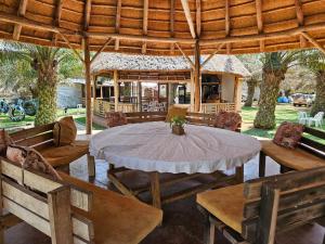 a patio with a table and chairs and a pavilion at Bugoma Palms Resort Sand Beach 