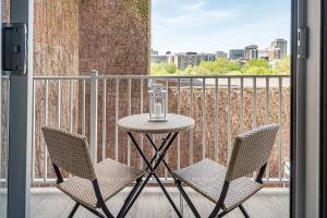 a table and two chairs on a balcony with a window at Urban Hideout - Downtown Haven in Montréal