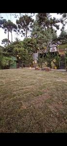 a field of grass with a house in the background at Chalét com jacuzzi sauna lareira e telao cinema in Campos do Jordão