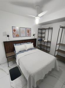 a bedroom with a large white bed and shelves at Lindo Apartamento em condomínio in Itatiba