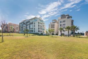 dos edificios altos en un parque con un campo de césped en Los Flamencos, en Isla Canela
