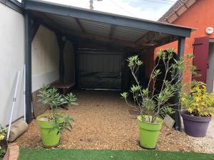 a garage with two potted plants in front of it at Maison Maurice in Le Mans +2 photos