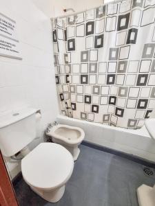 a bathroom with two toilets and a shower curtain at Casa Irupé in Embalse +15 photos