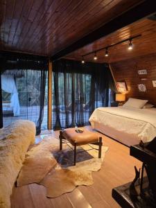 a bedroom with a bed and a table in it at Chalét com jacuzzi sauna lareira e telao cinema in Campos do Jordão +25 photos