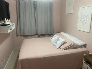a bed with two pillows on it in a bedroom at Apartamento em condomínio in Ananindeua