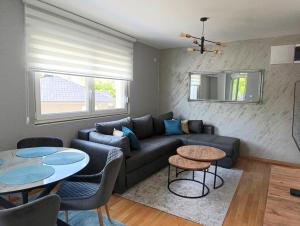 a living room with a couch and two tables at Apartman Hedon in Vrnjačka Banja
