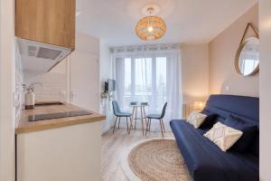 a kitchen and a living room with a blue couch at Great Cozy Studio - Paris in Bagnolet