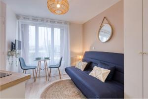 a living room with a blue couch and a table at Great Cozy Studio - Paris in Bagnolet