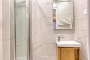 a white bathroom with a sink and a shower at Great Cozy Studio - Paris in Bagnolet