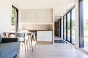 a kitchen and living room with a table and chairs at Contemporary design lake cabin in Otepää