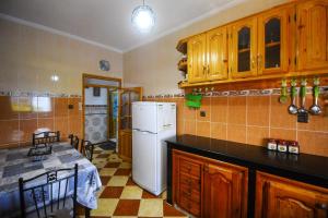a kitchen with wooden cabinets and a white refrigerator at Dar Boukhari Luxury Stay in Chefchaouene