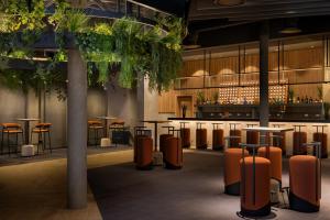 a bar with tables and stools in a building at Secrets Baby Beach Aruba Adults Only in Ceru Colorado