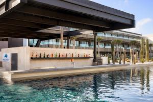 a building with a pool of water in front of a building at Secrets Baby Beach Aruba Adults Only in Ceru Colorado