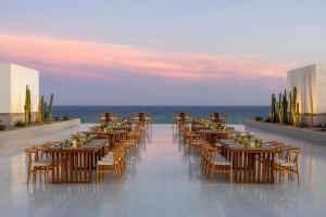 a restaurant with tables and chairs on a balcony with the ocean at Secrets Baby Beach Aruba Adults Only in Ceru Colorado +65 photos