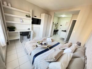 a living room with a bed and a desk at Travellar Spot 1317A in Ribeirão Preto