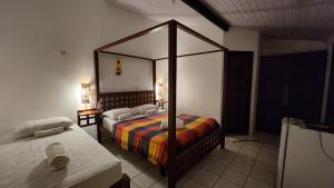 a bedroom with a canopy bed in a room at Pousada Vila Cajuína - Luís Correia in Luis Correia +55 photos
