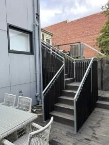 サンディ・ベイにあるRenovated apartment in central locationの椅子2脚とテーブル付きの階段