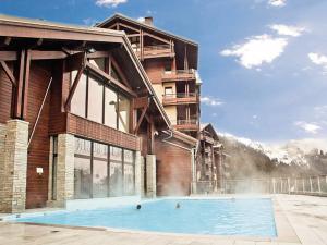 ein Gebäude mit einem Swimmingpool davor in der Unterkunft Appartement spacieux avec accès direct aux pistes, piscine, spa et WIFI – Flaine Montsoleil - FR-1-425-120 in Flaine