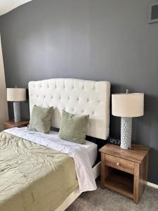 Un dormitorio con una cama grande con dos lámparas. en Family Home Minutes from Downtown Cincy, en Ludlow