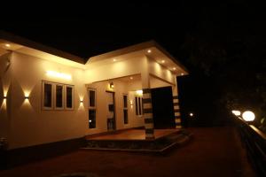 a small house lit up at night at MistAura Vagamon Tea Garden Cottage in Vagamon