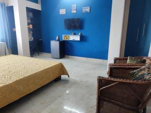 een slaapkamer met een bed en een blauwe muur bij GoFam in Dibrugarh