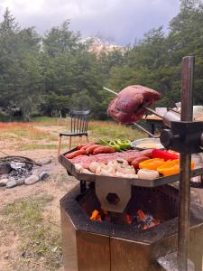Una parrilla con carne y verduras encima en Incredible Cerro Castillo Shelter, en Villa Cerro Castillo
