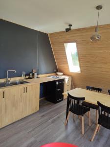 Una cocina con gabinetes de madera y una mesa con sillas. en Incredible Cerro Castillo Shelter, en Villa Cerro Castillo