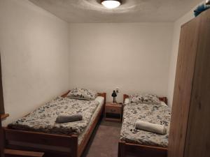 a bedroom with two beds and a table with a lamp at Ubytovanie Hrabiny in Sučany