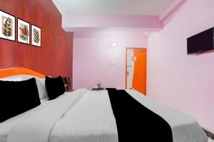 Un dormitorio con una cama grande y un televisor. en Hotel O The Triotel Inn, en Dhanbād