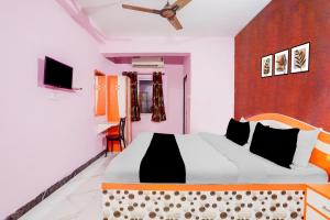 un dormitorio con una cama grande en una habitación en Hotel O The Triotel Inn, en Dhanbād