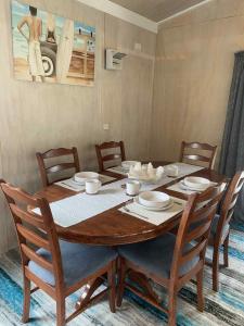 - une table à manger avec des chaises, une table en bois et des chaises dans l'établissement Hosts on the Coast Pawprint Cabins, à Whitianga 21 autres photos