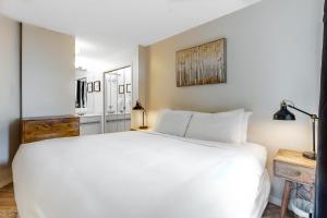 a bedroom with a large white bed and a table at The Marquise 321 in Whistler