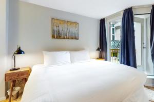 a bedroom with a large white bed and a window at The Marquise 321 in Whistler +10 photos