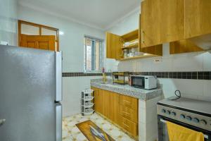 a kitchen with wooden cabinets and a stainless steel refrigerator at Royal Suites in Mombasa