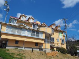 un gran edificio amarillo en la cima de una colina en olive no sato vingh four eyes shodoshima / Vacation STAY 79069, en Kusakabe