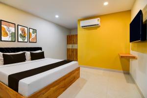 a bedroom with a bed and a yellow wall at Hotel O MOODY MOON.02 in Bālianta