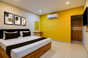 a bedroom with a bed with a yellow wall at Hotel O MOODY MOON.02 in Bālianta