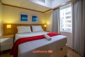 a bedroom with a bed with a red blanket on it at Flat na Bela Cintra duas quadras da Av Paulista in Sao Paulo