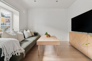 a living room with a couch and a flat screen tv at Central loft apartment, with a view from the roof terrace in Tromsø +17 photos